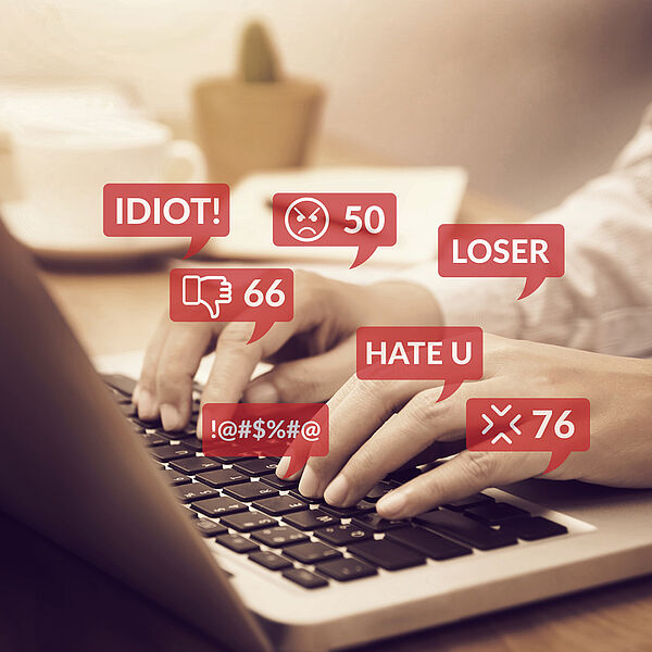 Das Bild zeigt einen Internetnutzer, der am Laptop Hass-Kommentare tippt