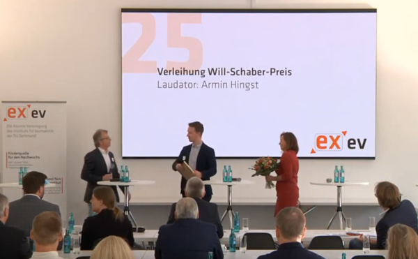 Der Vorsitzende des EX e.V. Armin Hingst verleiht den diesjährigen Will-Schaber-Preis an Daniel Schmitz, Absolvent des Wirtschaftspolitischen Journalismus.