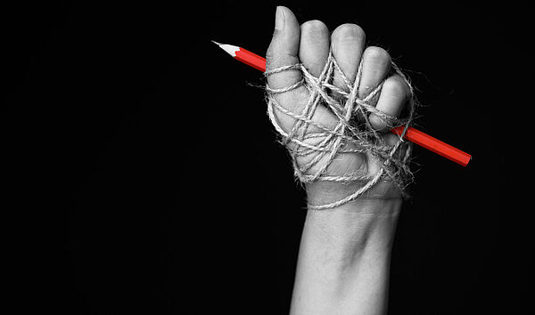 Faust, die einen Bleistift hält