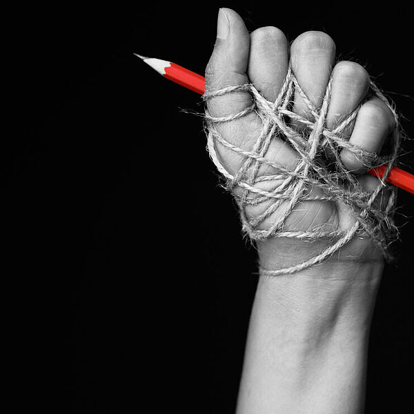 Faust, die einen Bleistift hält