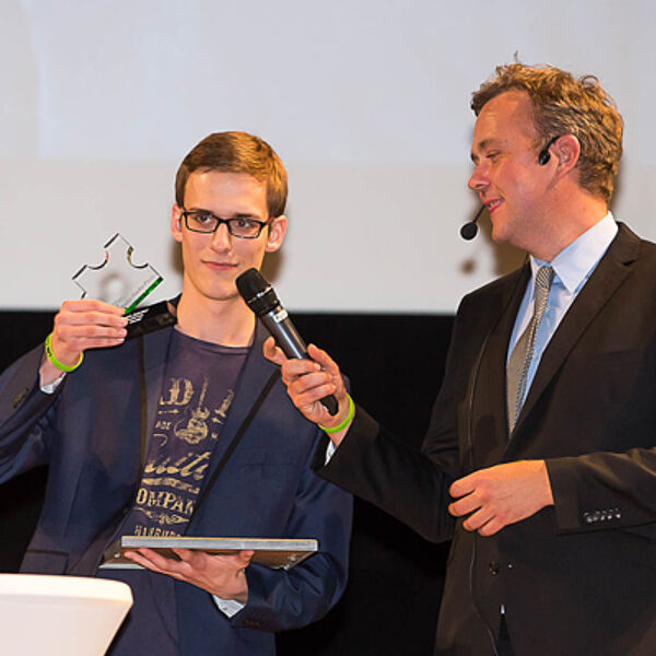 Philipp von Kagenec überreicht Hendrik Frost (eldoradio*) den LfM-Campus-Radio-Preis für die "Beste Moderation". Foto: Uwe Völkner/LfM