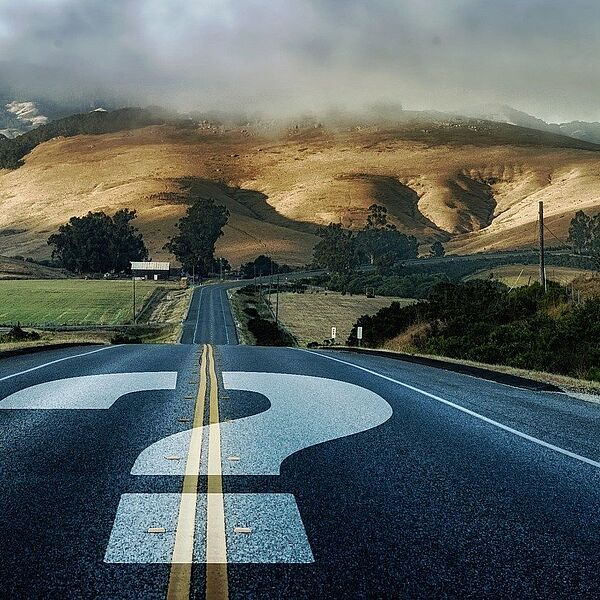 Straße mit Fragezeichen - symbolisiert einen ungewissen Weg